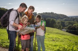 Familie schaut in eine Wanderkarte